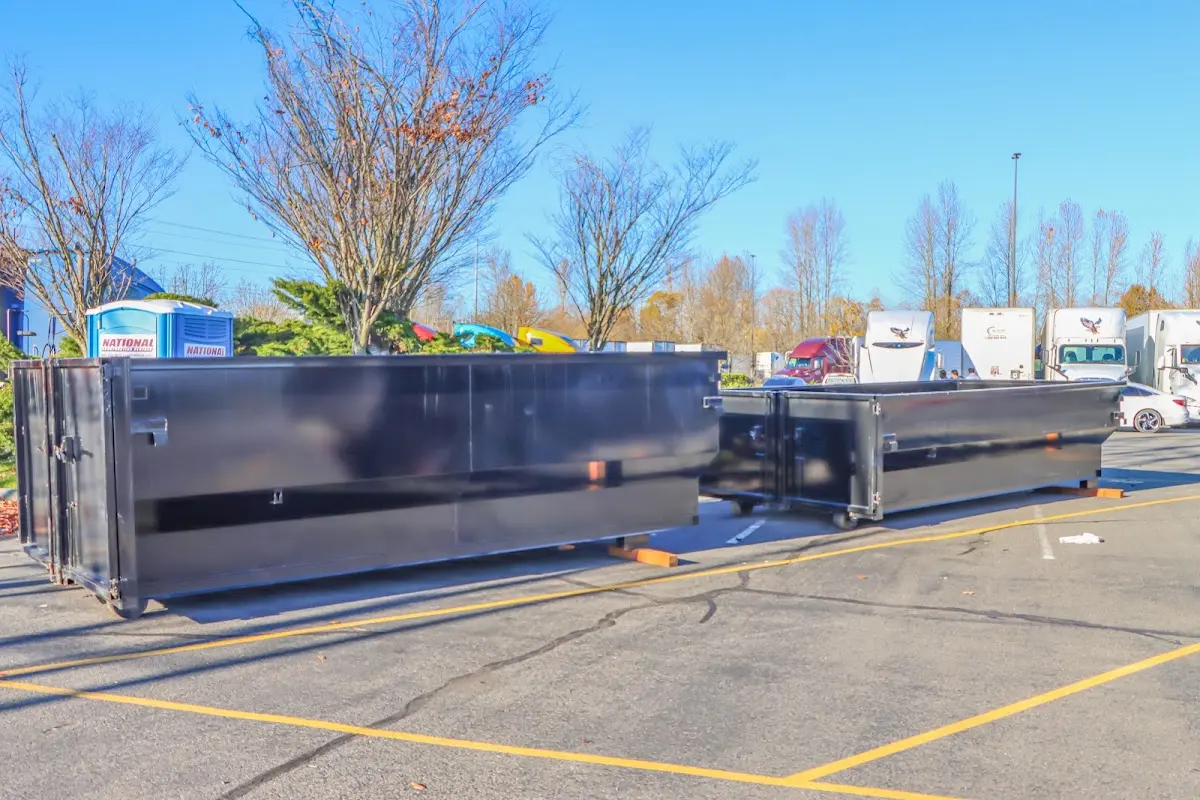 Professional dumpster rental service with roll-off container on residential driveway in Pawtucket